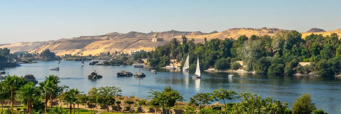 Consejos de Fotografía en Egipto Vista aérea del río Nilo con falucas (barcos de vela tradicionales egipcios) al atardecer en Asuán, Egipto.