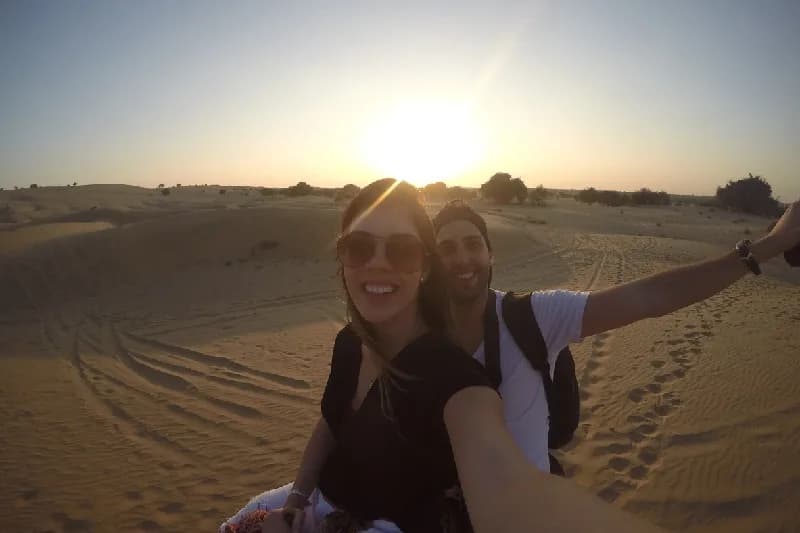 Celebra tu Aniversario como Nunca: Paquetes Románticos Exclusivos Pareja tomándose un selfie en un camello en el desierto