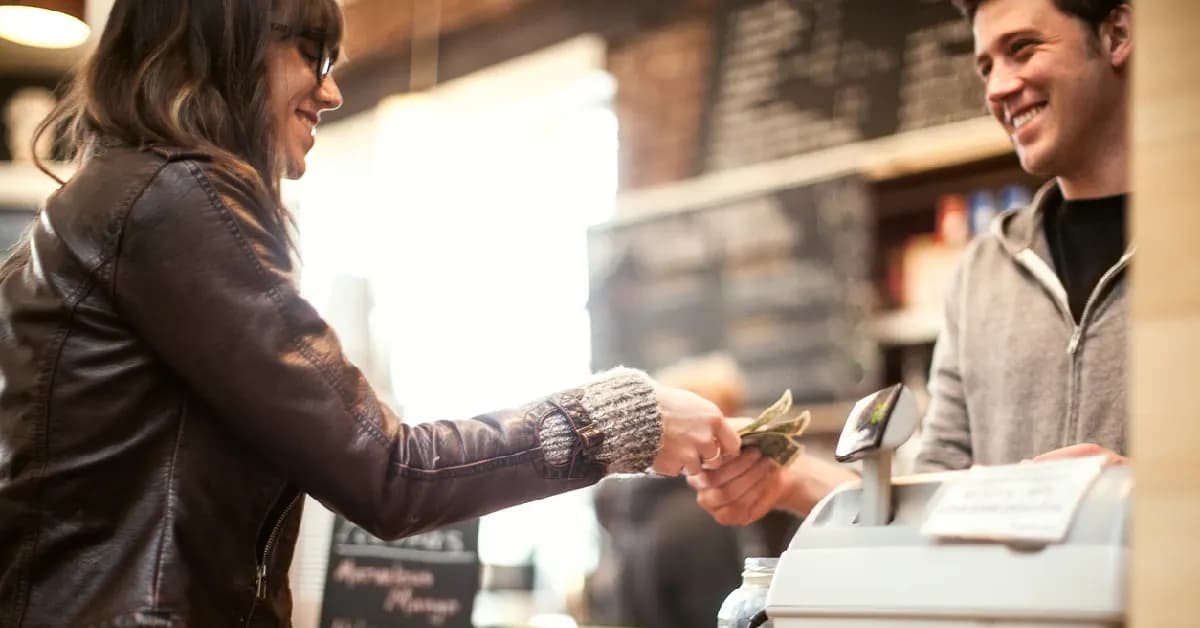 Pago en efectivo en comercio. Una mujer regateando con un cajero en una tienda