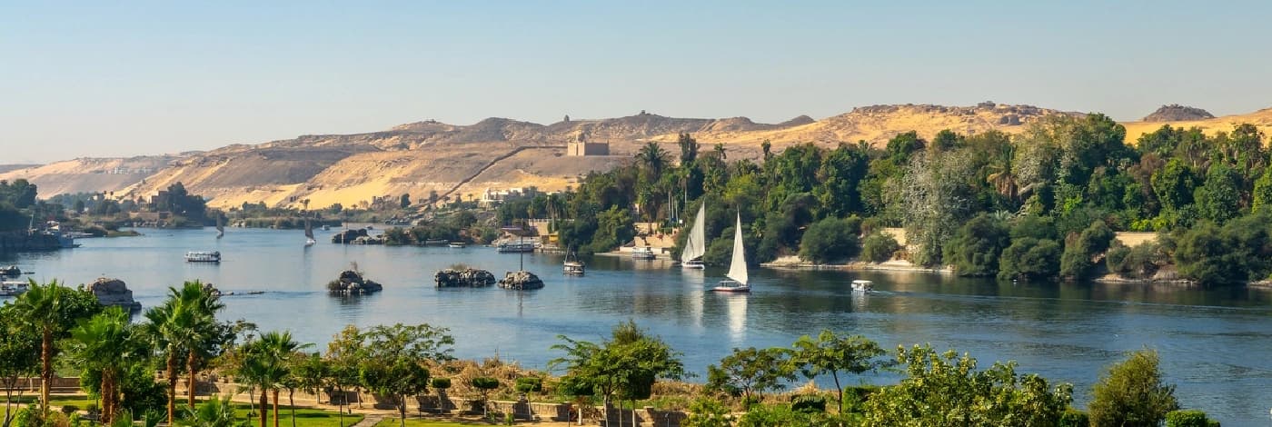 Consejos de Fotografía en Egipto Vista aérea del río Nilo con falucas (barcos de vela tradicionales egipcios) al atardecer en Asuán, Egipto.